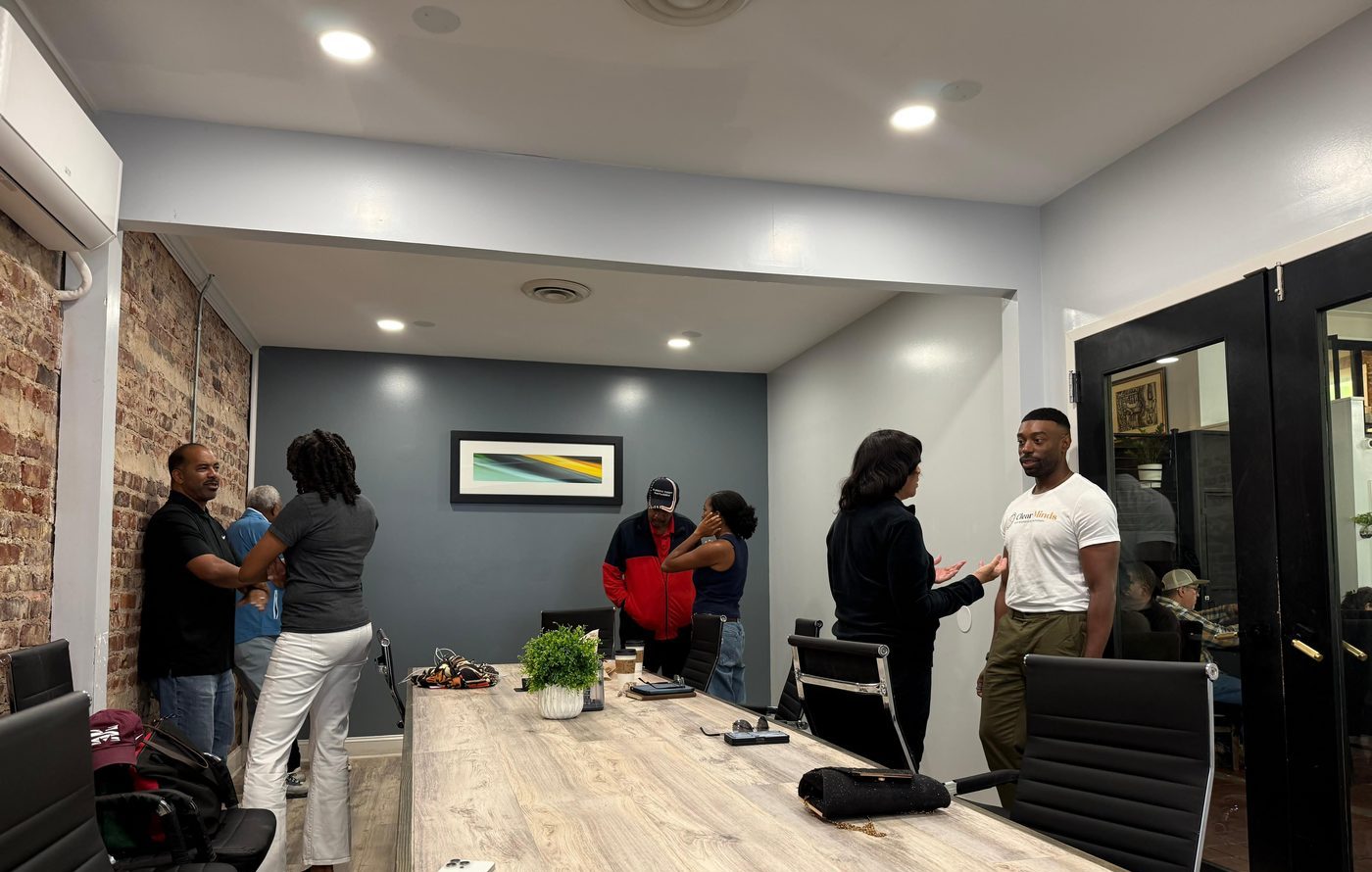 Members talking in small groups around a long conference table at an in-person MAABPsi meeting